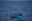 Inmitten von Wasser ein kleines blaues Boot und daneben das Schnellboot von SOS Humanity