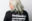 Josi Miller mit blondierten Haaren von hinten beim Tragen eines SOS Humanity Merchandise T-Shirt in schwarz