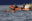 Foto eines RHIBs von SOS Humanity und mehreren Menschen mit Rettungswesten im Wasser