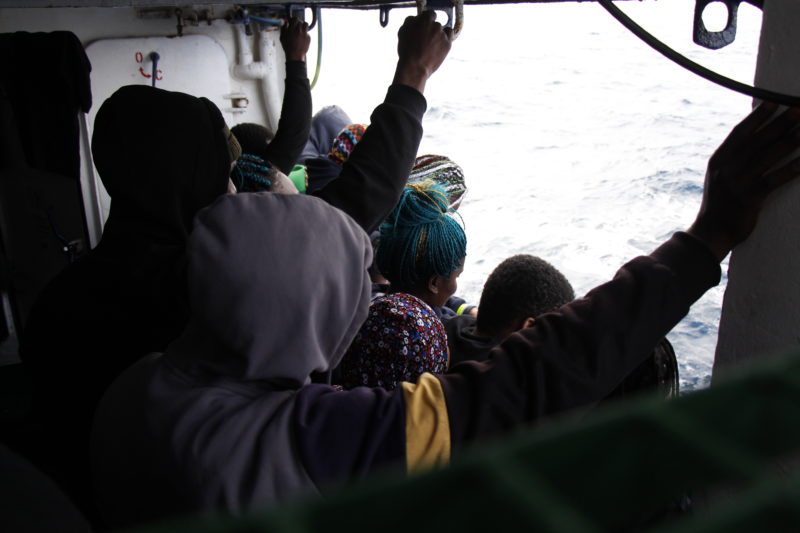 Gerettete Frauen und Mädchen blicken von der Reling aus auf das Meer.
