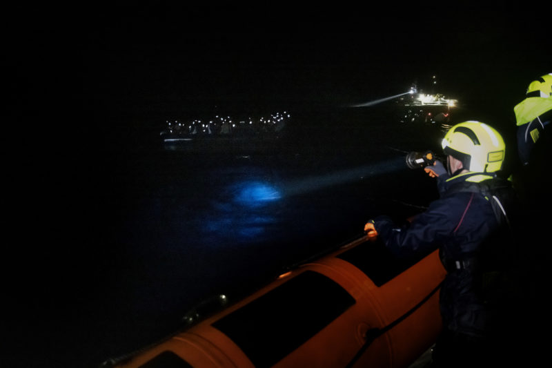 Mitglieder des Rettungsteams leuchten bei einem NAchteinsatz zu einem überbesetzten Schlauchboot