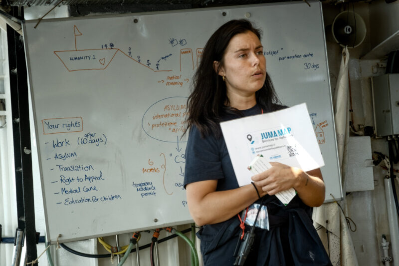 Olive bei der Erklärung von Informationen zum Asylverfahren in Italien für die Geretteten an Bord der Humanity 1.
