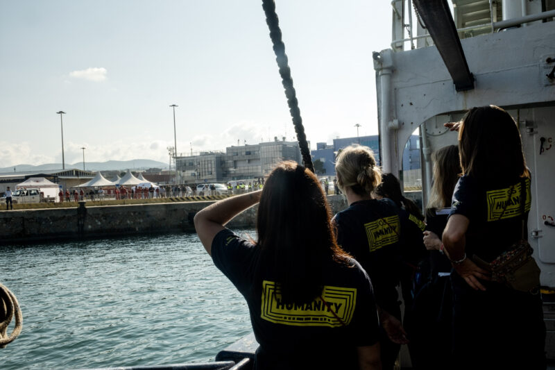 Weibliche Crewmitglieder von hinten an Bord der Humanity 1 mit Blick auf Italien.