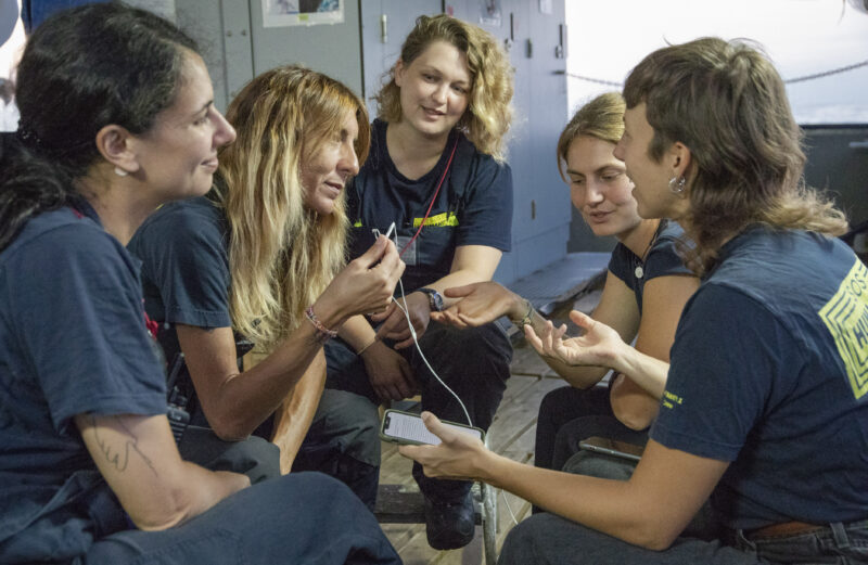 Fünf Frauen in SOS T-Shirts im Gespräch an Bord des Rettungsschiffes Humanity 1.