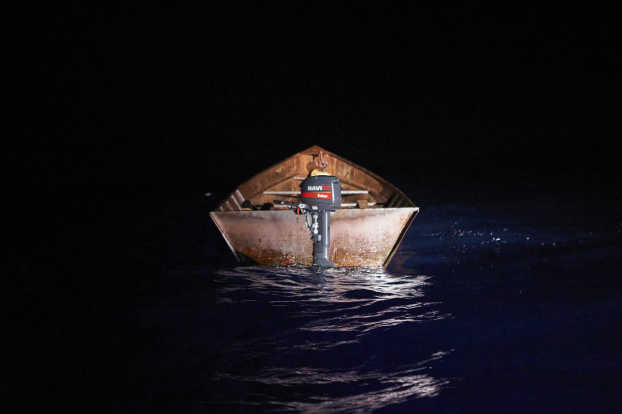 Braunes, leeres Metallboot im Wasser bei Nacht.