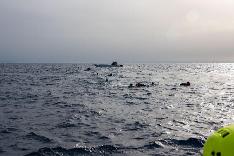Menschen im Wasser zwischen hohen Wellen