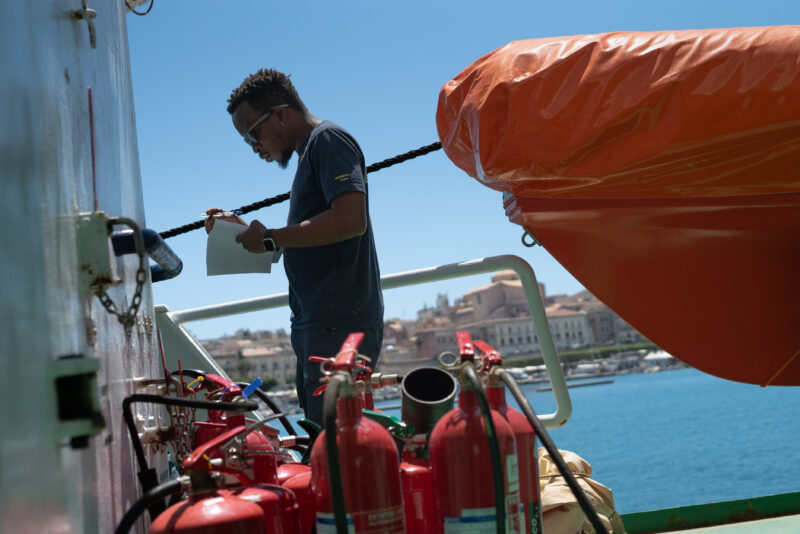 Ein Crewmitglied steht an Bord der Humanity 1 und füllt ein Formular aus.