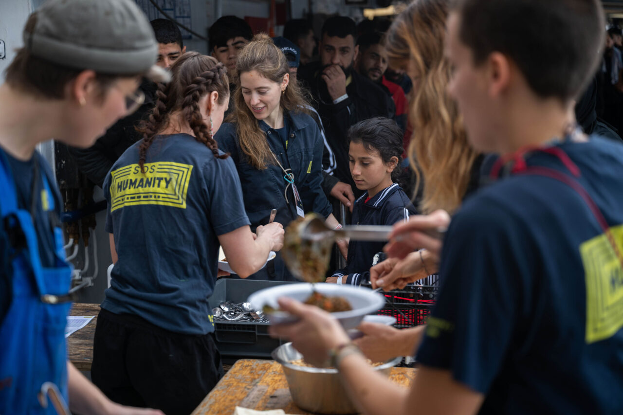 Crew und Überlebende essen gemeinsam an Deck
