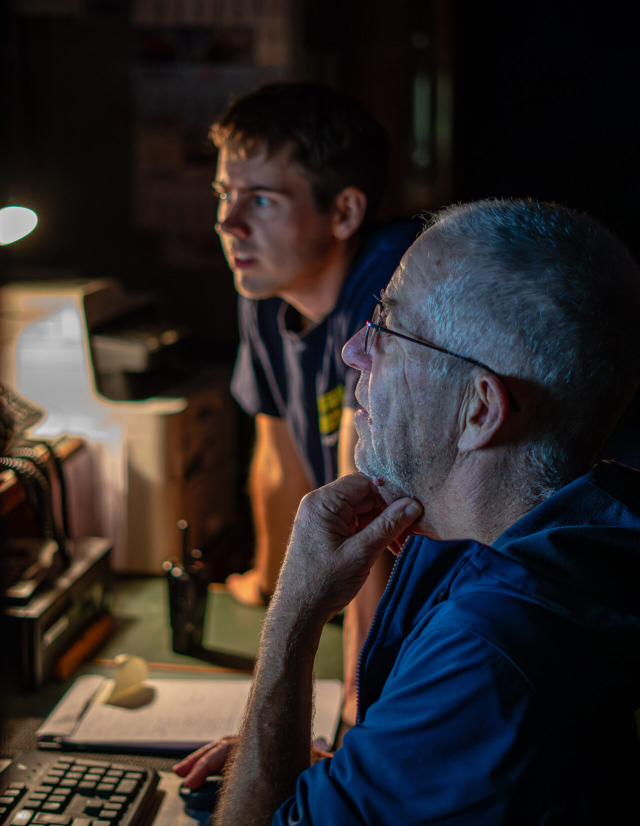 Kapitän Joachim und der Menschenrechtsbeobachter Louis gucken zusammen auf einen Computer an Bord des Rettungsschiffes Humanity 1.