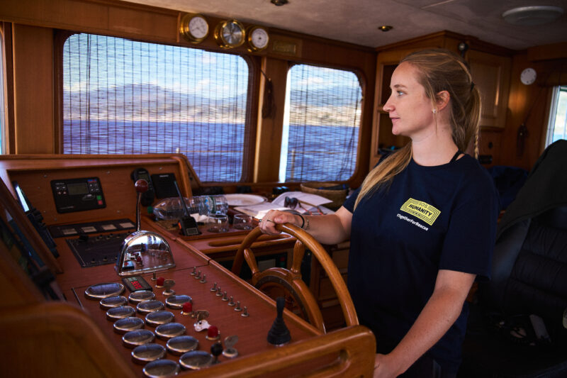 Frau steuert das Boot.
