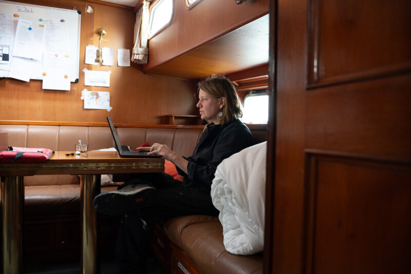 Frau an Board arbeitet am Laptop.